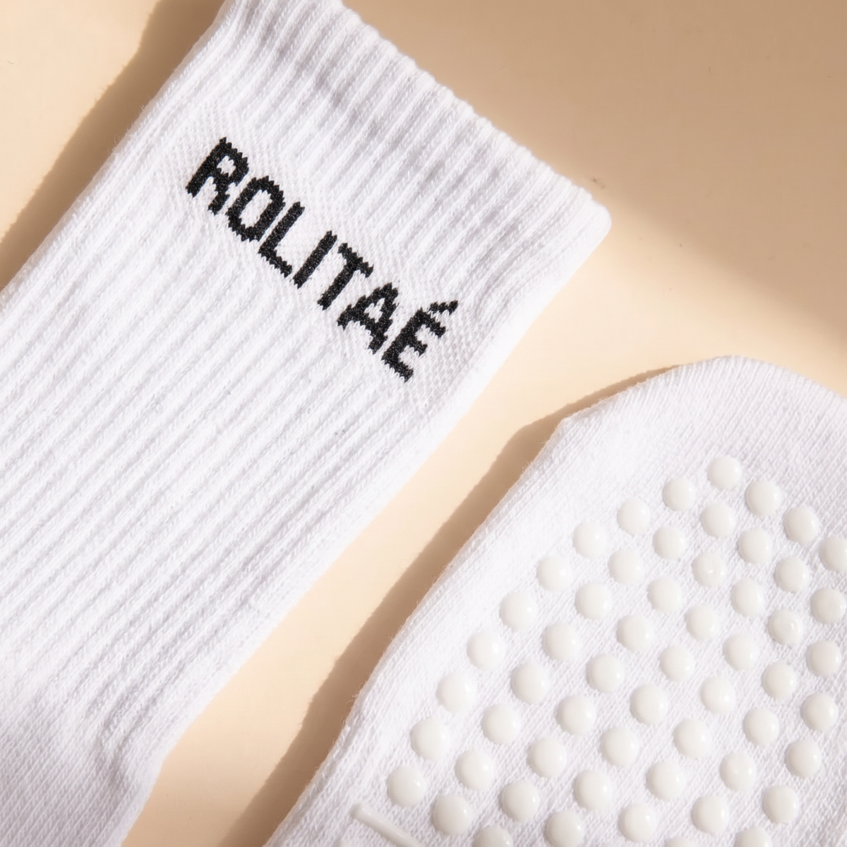 Witte pilates sokken close-up van de boord met ROLITAE logo en de siliconen antislip grip zool